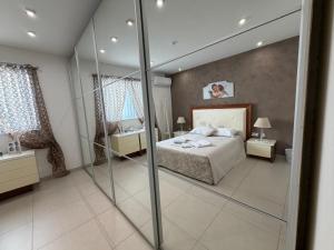 a bedroom with a bed and a mirror at S'Agapo Maisonette St' Julians in St. Julianʼs
