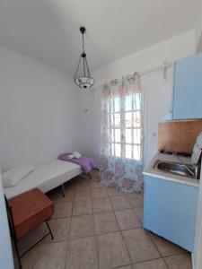 a small kitchen with a bed and a window at Hotel Posidonion in Koufonisia +49 photos