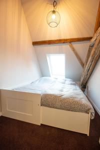 a bed in a small room with a window at Huize de Lekpoort - The Stork Loft - Loft Apartment in Vianen Center in Vianen
