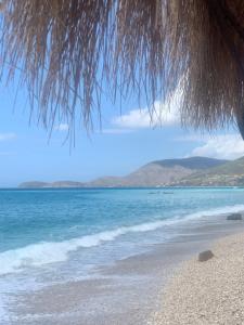 a view of the ocean from under a beach umbrella at Vila Kalluci in Borsh