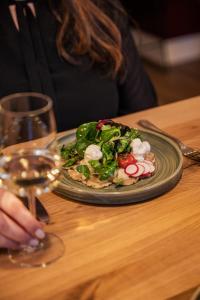 a plate of food on a table with a glass of wine at Das Mühlentor Hotel mit Restaurant - moderne Zimmer - leckere Heimatküche - familiär geführt in Bad Kreuznach