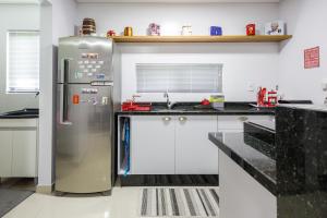 a kitchen with a stainless steel refrigerator at Little Britain no centro de Pomerode in Pomerode