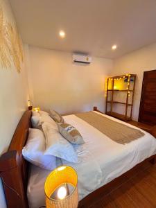 a bedroom with a large bed with white sheets and pillows at Jungle Hideaway with Pool Wifi Smart TV in Ban Tai +16 photos