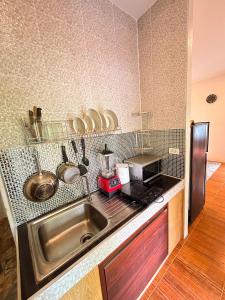 a kitchen with a sink and a microwave at Jungle Hideaway with Pool Wifi Smart TV in Ban Tai