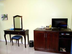a room with a vanity with a mirror and a tv at Caimito Beach Hotel in Ichon