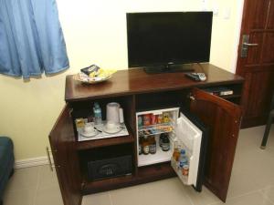 a desk with a television and a small refrigerator at Caimito Beach Hotel in Ichon