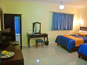 a bedroom with two beds and a desk with a mirror at Caimito Beach Hotel in Ichon +58 photos
