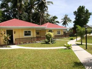 a yellow house with a red roof at Caimito Beach Hotel in Ichon