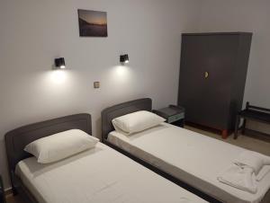 two twin beds in a room with a piano at Dina Apartments Kokkari, Pension Dina, Dina Rooms in Kokkari +49 photos