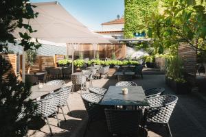 a patio with tables and chairs and an umbrella at Das Mühlentor Hotel mit Restaurant - moderne Zimmer - leckere Heimatküche - familiär geführt in Bad Kreuznach