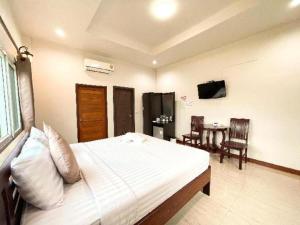 a bedroom with a bed and a table with chairs at janwareeresort in Sangkhla Buri