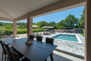 a patio with a table and chairs and a swimming pool at Villa Ardanela in Labin