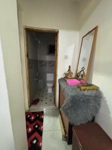 a bathroom with a sink and a mirror and a toilet at Mombasa 1 Bedroom Apartment in Mombasa