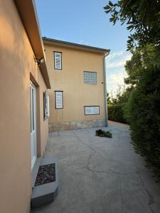 a building with a driveway next to a house at Studio Apartman ISRA 1 in Palit
