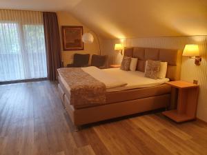 a hotel room with a large bed and a window at Hotel Garni Eichhornkobel in Faßberg
