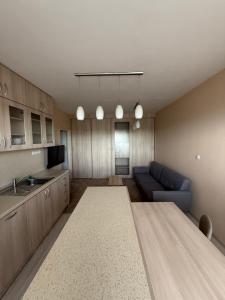a kitchen and living room with a couch and a table at Apartmán Košice Nad Jazerom in Košice