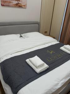 a bed with two folded towels on top of it at Luxoria hotel in Astana