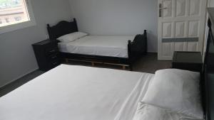 a bedroom with two twin beds and a window at Acacia Nest in Tangier