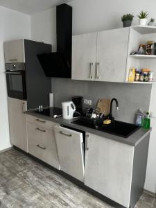 a kitchen with white cabinets and a black counter top at Ferienwohnung Krayenbergblick 2 in Tiefenort