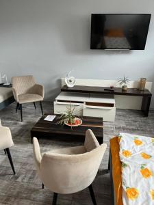 a living room with a tv and a table and chairs at Ferienwohnung Krayenbergblick 2 in Tiefenort