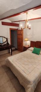 a bedroom with a large bed and a table at Casa la Solana 1915 in Lucena del Cid