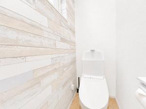 a bathroom with a white toilet and a wooden wall at 優富良野 in Furano +25 photos