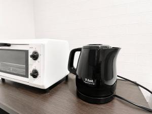 a tea kettle next to a microwave on a table at 優富良野 in Furano
