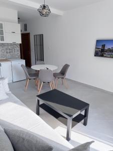a living room with a couch and a table and chairs at Quattro Rocce Apartments Zelen in Sutomore +42 photos