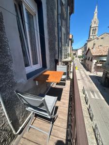 a table and chairs on the side of a building at Appartement 5 - T2 Meublé 2 étoiles proche des thermes in Vals-les-Bains
