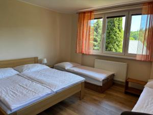 a bedroom with two beds and a window at ubytovanie Vážka in Banská Štiavnica