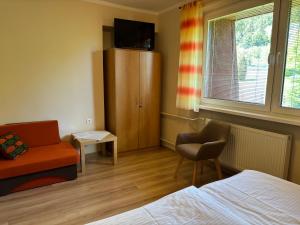 a bedroom with a bed and a chair and a cabinet at ubytovanie Vážka in Banská Štiavnica