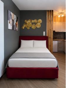 a bedroom with a large bed with a red headboard at GPX CLR - MicroLuxe Suite in Larisa