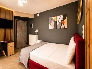 a bedroom with a large bed and a red couch at GPX CLR - MicroLuxe Suite in Larisa