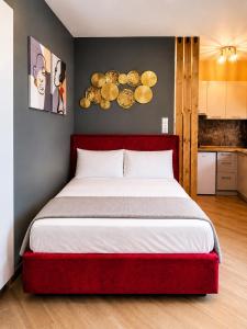 a bedroom with a large bed with a red headboard at GPX CLR - MicroLuxe Suite in Larisa +16 photos