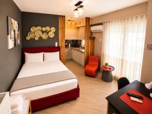 a bedroom with a bed and a desk and a kitchen at GPX CLR - MicroLuxe Suite in Larisa