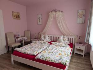 ein Schlafzimmer mit einem großen Bett mit Himmelbett in der Unterkunft Pension Sander in Bispingen