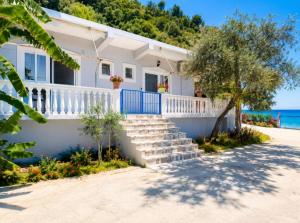 a white house with stairs in front of the ocean at Wonderful Sea View in Borsh