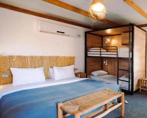 a bedroom with a bed and a bunk bed at Amara Travel in Zuqim