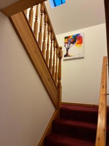 a staircase in a home with a wooden stair case at Lotties Neuk in Lerwick