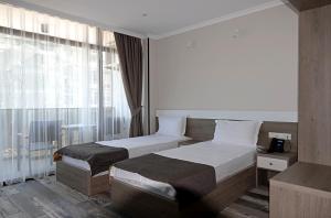 a hotel room with two beds and a window at Hotel Green Rock in Kvariat'i +75 photos