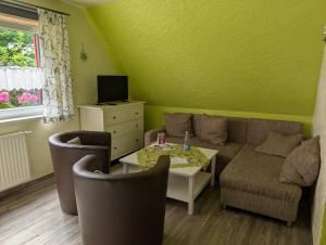 ein Wohnzimmer mit Sofa und Tisch in der Unterkunft Pension Sander in Bispingen