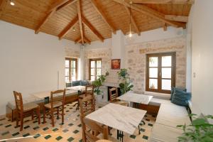 a room with tables and chairs and a room with a fireplace at Atman Eco Lodge in Gliki
