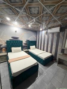 a room with two beds in a room at Karachi Family Guest House in Karachi