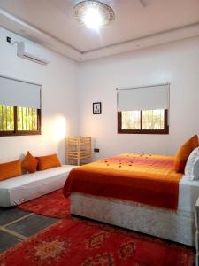 a bedroom with two beds and two windows at فيلا رياض عمران in Douar Blidene +79 photos