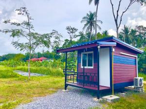 a colorful tiny house sitting on top of a field at Lamai Home 2 in Ko Yao Noi