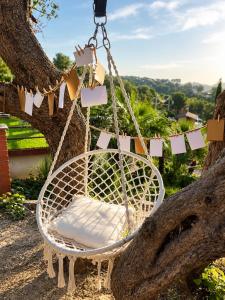 a swing hanging from a tree with cards at Villa Wanderlust Sitges Hills Exclusive pool only families in Olivella