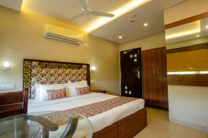 a bedroom with a bed and a glass table at Hotel Jullundur 18 in Chandīgarh +11 photos