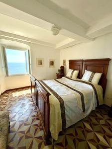 a bedroom with a large bed with a large window at Appartamento con terrazza vista mare nel borgo in Framura