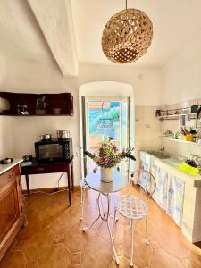 a kitchen with a table with a vase of flowers on it at Appartamento con terrazza vista mare nel borgo in Framura +23 photos