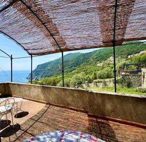 a patio with a view of the ocean and mountains at Appartamento con terrazza vista mare nel borgo in Framura